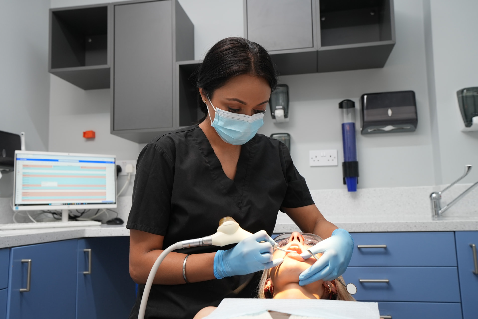 Dentist polishing a patient's teeth at Welling Dental Studio